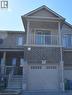 Contemporary townhome facade featuring a full-width balcony with sliding glass doors, a single-car garage with transom windows, and a brick and siding exterior - 52 Meadowridge Street, Kitchener, ON 