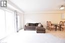Spacious room featuring light-toned carpeting, a large sliding glass door, and a built-in ceiling light fixture - 52 Meadowridge Street, Kitchener, ON 