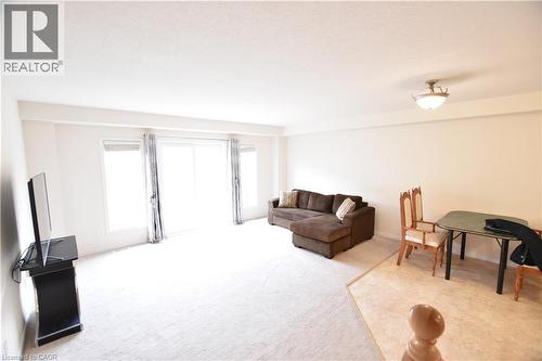 Spacious room featuring light-colored carpeting, white walls, and a large sliding glass door opening to the exterior - 52 Meadowridge Street, Kitchener, ON 