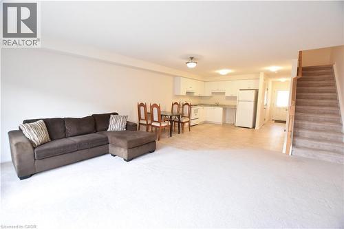 Open-concept living area with light-toned walls and contrasting floor finishes - 52 Meadowridge Street, Kitchener, ON 