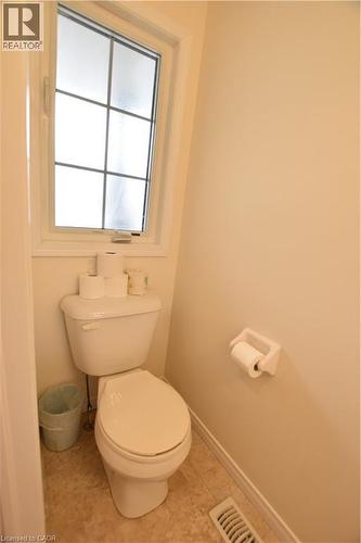 Powder room featuring a multi-paned window, neutral wall paint, and resilient flooring - 52 Meadowridge Street, Kitchener, ON 