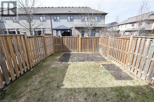 Private backyard space with wood fencing and dedicated garden beds - 52 Meadowridge Street, Kitchener, ON 