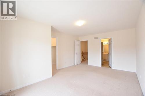 Carpeted room featuring light-colored walls and a semi-flush mount ceiling light - 52 Meadowridge Street, Kitchener, ON 