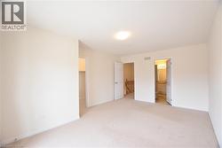 Carpeted room featuring light-colored walls and a semi-flush mount ceiling light - 