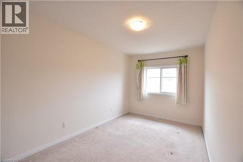Neutral-toned wall paint and light-colored carpet flooring create a bright interior space - 52 Meadowridge Street, Kitchener, ON 