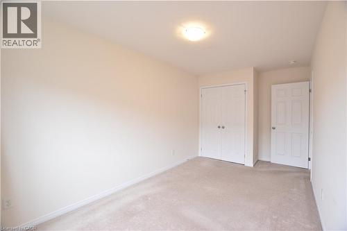 Neutral-toned room featuring light beige carpeting and white painted walls - 52 Meadowridge Street, Kitchener, ON 