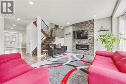 Living area with a stacked stone accent wall featuring an electric fireplace and mounted television - 