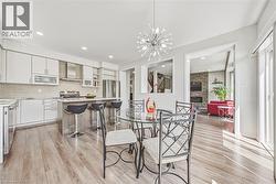 Open-concept kitchen and dining area featuring wood-finish flooring - 