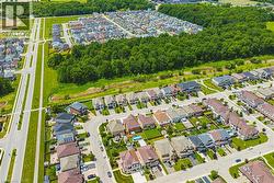 Aerial depiction of a residential neighborhood with diverse architectural styles, featuring paved roadways and green spaces - 