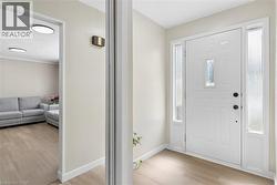 Entryway featuring a white paneled door with decorative glass insert and sidelights - 