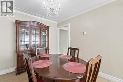 Formal dining area featuring neutral wall tones, crown molding, and a crystal chandelier - 
