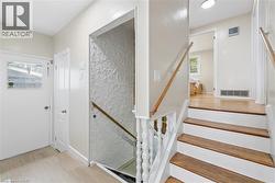 Entryway featuring light wood-finish flooring and a white door with a window pane - 