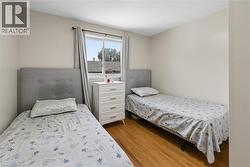 Room featuring a window with natural light, wood-finish flooring, and neutral wall paint - 