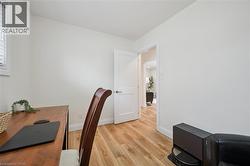 Office area with light wood-style flooring and baseboards - 