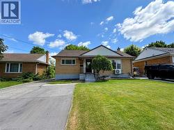 Traditional brick exterior with a pitched shingle roof, featuring a front porch with steps and a manicured lawn - 