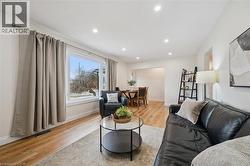 Living room with light wood-style floors and recessed lighting - 