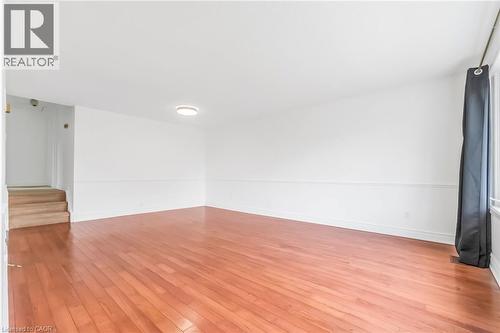 Bright interior space featuring wood-finish flooring, white walls, and a recessed ceiling light fixture - 1259 Ernest Avenue, London, ON - Indoor Photo Showing Other Room