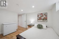 Bedroom with light wood finished floors and recessed lighting - 