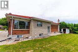 Brick and stone exterior featuring a red roof and multiple windows - 