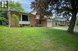 Brick-clad exterior with a prominent bay window, attached single-car garage, and a concrete driveway - 