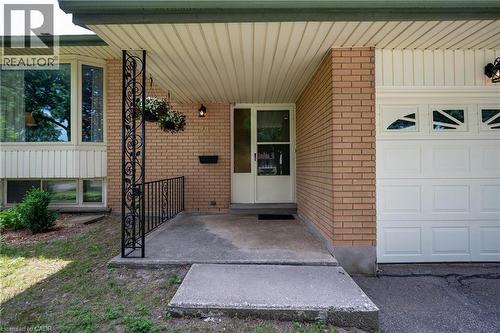 Brick exterior with a covered entryway, featuring a decorative wrought iron support column and railing - 99 Lorraine Avenue, Kitchener, ON - Outdoor With Exterior