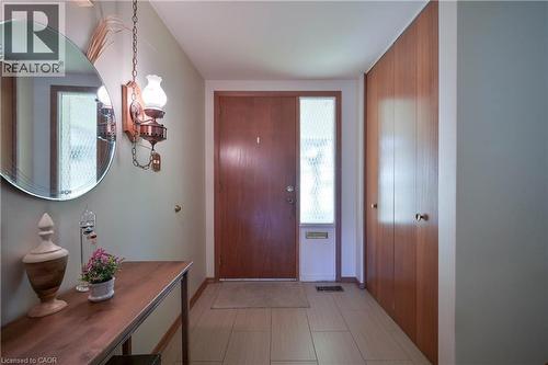 Entryway featuring a wood-panel door with a sidelight, light-toned tile flooring, and built-in wood cabinetry - 99 Lorraine Avenue, Kitchener, ON - Indoor Photo Showing Other Room
