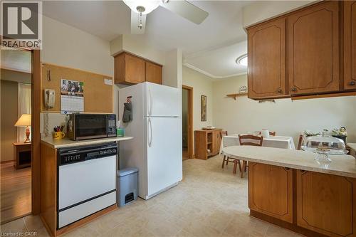 Kitchen featuring wood cabinetry, light-toned countertops, and tile flooring - 99 Lorraine Avenue, Kitchener, ON - Indoor Photo Showing Kitchen