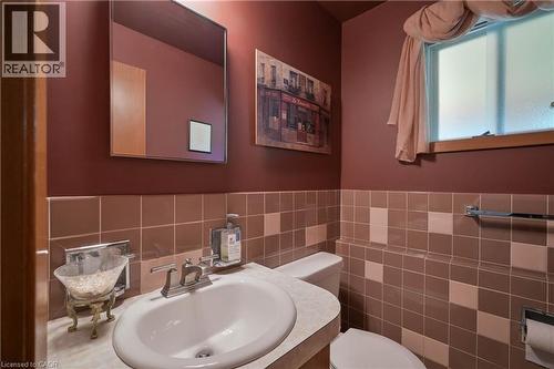 Bathroom featuring a white porcelain sink, a counter-mounted faucet, and a toilet - 99 Lorraine Avenue, Kitchener, ON - Indoor Photo Showing Bathroom