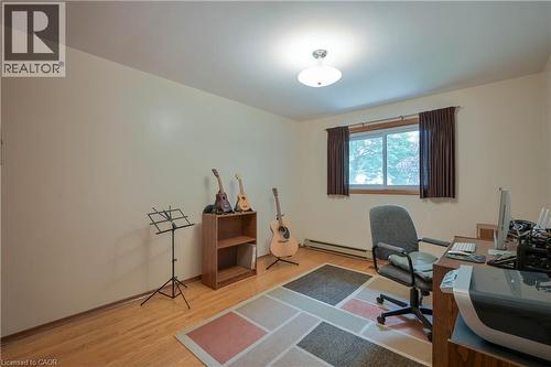 Bright room featuring wood-finish flooring, a flush-mount ceiling light fixture, and a window with a wood-tone frame - 99 Lorraine Avenue, Kitchener, ON - Indoor Photo Showing Office