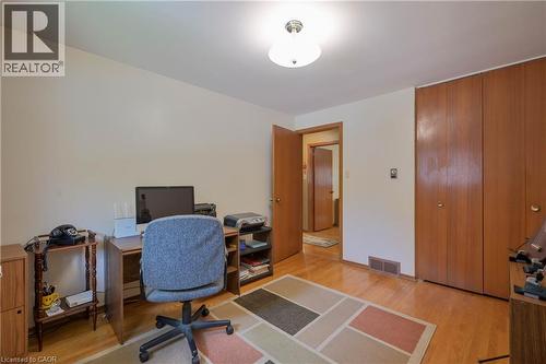 Hardwood flooring throughout, neutral wall tones, and built-in wood-finish closet doors - 99 Lorraine Avenue, Kitchener, ON - Indoor Photo Showing Office