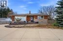View of front facade with a chimney, stone siding, brick siding, and roof with shingles - 473 Mohawk Road W, Hamilton, ON 
