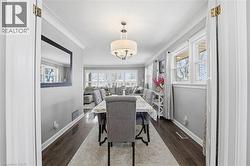Dining room featuring dark wood-style flooring, plenty of natural light, and ornamental molding - 