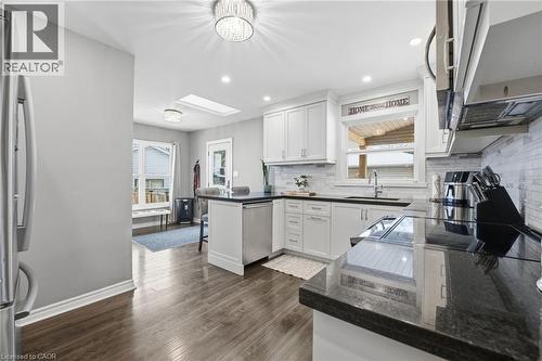 Kitchen featuring a peninsula, white cabinetry, stainless steel appliances, healthy amount of natural light, and recessed lighting - 473 Mohawk Road W, Hamilton, ON 