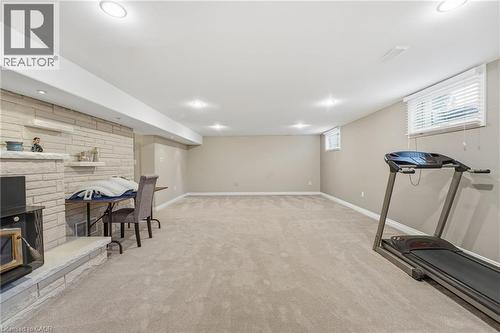 Workout room with a fireplace, light carpet, and recessed lighting - 473 Mohawk Road W, Hamilton, ON 