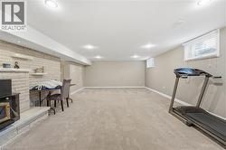 Workout room with a fireplace, light carpet, and recessed lighting - 