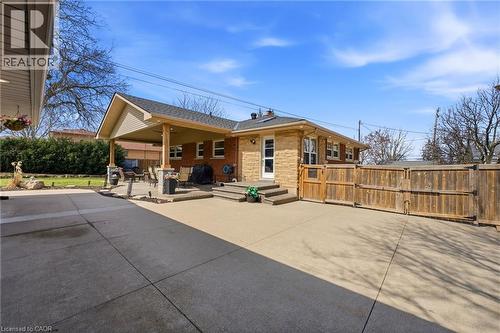 Rear view of property with a patio area, a gate, and brick siding - 473 Mohawk Road W, Hamilton, ON 