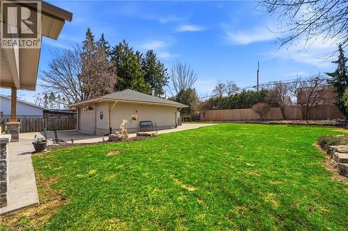 Fenced backyard with a patio area, a detached garage, and an outbuilding - 473 Mohawk Road W, Hamilton, ON 