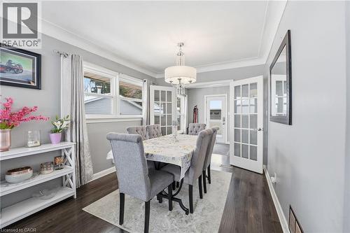 Dining area featuring dark wood finished floors and ornamental molding - 473 Mohawk Road W, Hamilton, ON 