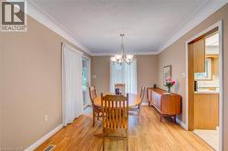 Dining area featuring wood-finish flooring, a decorative ceiling medallion, and crown molding - 