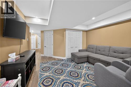 Recreation room featuring recessed lighting, wood-finish flooring, warm-toned walls, and multiple white paneled doors - 149 Kinsman Drive, Binbrook, ON 