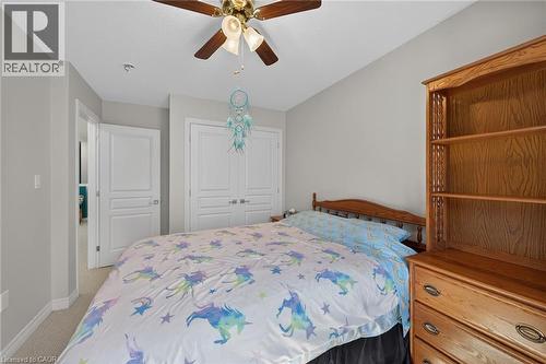 Carpeted room featuring a ceiling fan with integrated lighting, a paneled door, and a bi-fold closet door - 149 Kinsman Drive, Binbrook, ON 