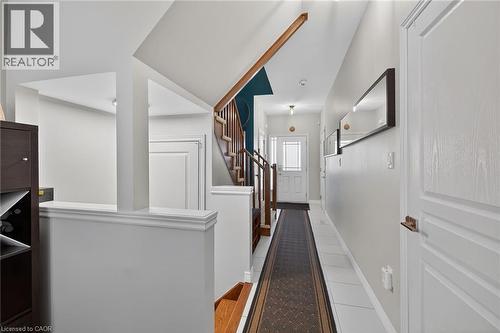 Entryway featuring a white paneled door with frosted glass insert, white tile flooring, and a stairway with wood handrails and risers - 149 Kinsman Drive, Binbrook, ON 