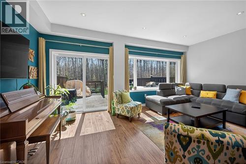 Living area featuring wood-finish flooring, recessed lighting, and a large sliding glass door opening onto an outdoor deck - 149 Kinsman Drive, Binbrook, ON 