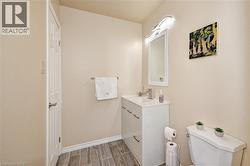 Bathroom featuring a single vanity with storage, a rectangular mirror, and a wall-mounted light fixture - 