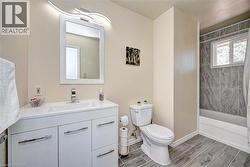 Bathroom featuring a white vanity with integrated sink, chrome faucet, and contemporary vanity lighting - 