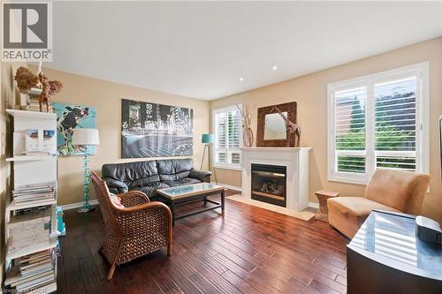 Family Room featuring dark wood-finish flooring, a white mantel gas fireplace, and recessed lighting - 207 Valridge Drive, Ancaster, ON - Indoor Photo Showing Living Room With Fireplace