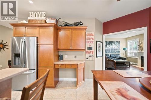 Kitchen featuring wood-finish cabinetry, stainless steel refrigerator, and integrated desk area - 207 Valridge Drive, Ancaster, ON - Indoor