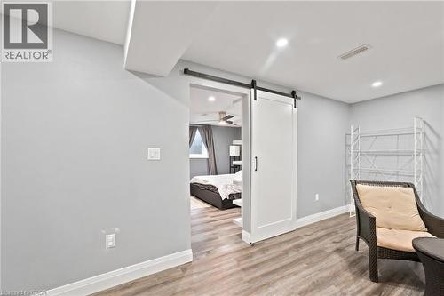 Basement sitting room leading to bedroom with barn-style sliding door - 207 Valridge Drive, Ancaster, ON - Indoor