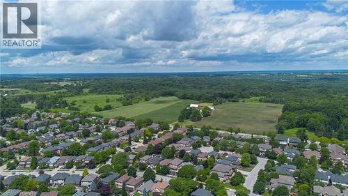 Aerial perspective showcasing a residential community bordered by expansive green spaces and wooded areas - 207 Valridge Drive, Ancaster, ON - Outdoor With View