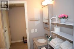 Bathroom vanity featuring a speckled countertop, undermount sink, and chrome faucet - 